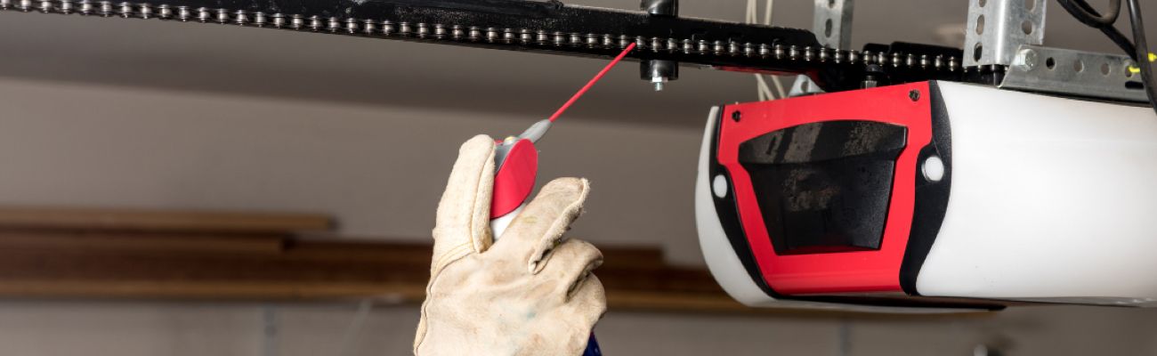 Technician Lubricating Garage Door Opener Chain